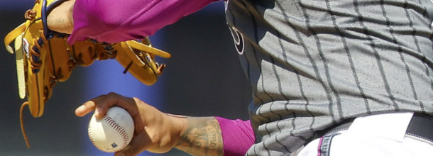 A Major League Baseball pitcher winds up on the mound