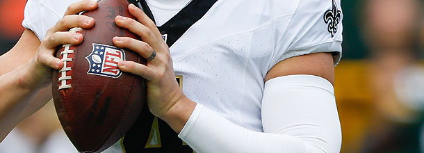 An NFL quarterback holds the ball before launching a downfield pass