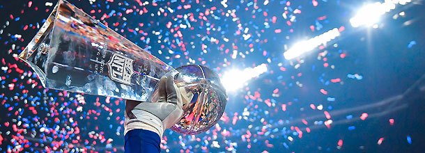 An NFL player holds the Vince Lombardi Trophy aloft after winning the Super Bowl