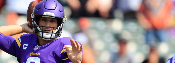 Minnesota Vikings QB Kirk Cousins launches a long pass downfield in an NFL game