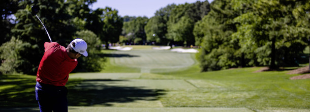 A golf player hits a tee shot at Quail Hollow