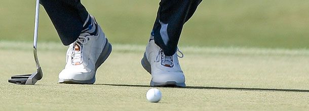 A golf player lines up a putt on the PGA Tour