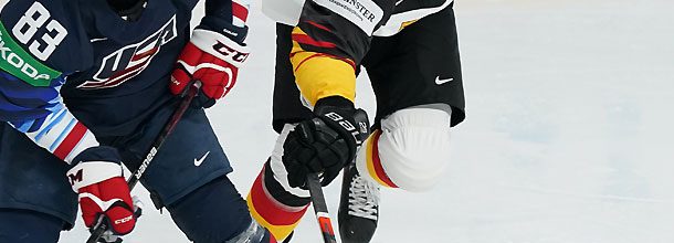 Eishockey players from the USA and Germany battle for the puck at the Olympic Games