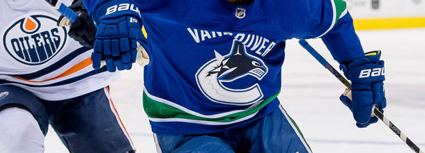 Ice hockey players from the Edmonton Oilers and Vancouver Canucks in action in the NHL.