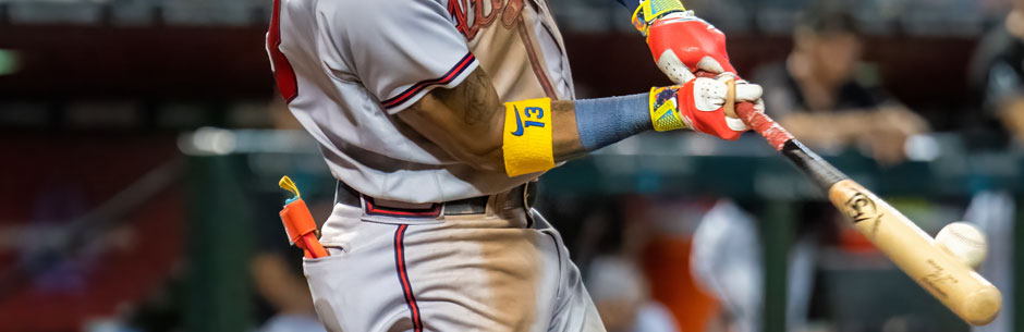 An MLB baseball player hits a pitch