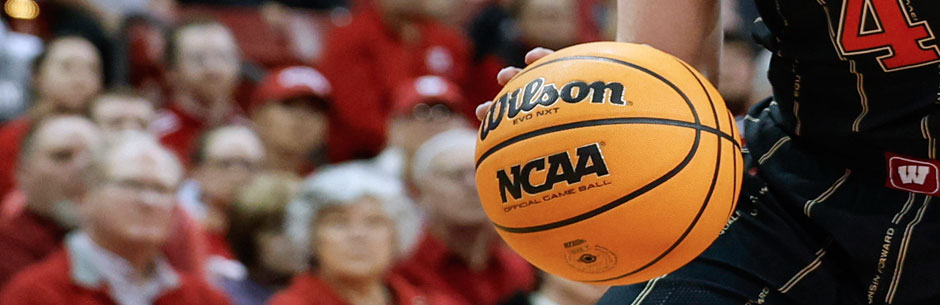 A college basketball player dribbles an official NCAAB ball
