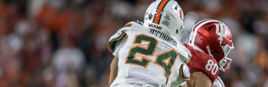 Players from the Indiana Hoosiers and Miami Hurricanes battle for the ball in the NCAAF