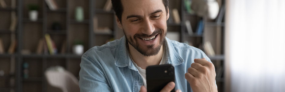 A man looks really happy after receiving a bonus SMS
