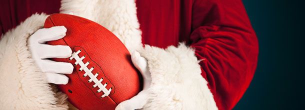 Santa Claus holds an American football in his hands