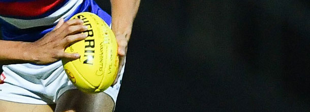 An Aussie Rules player carries the ball in the AFL