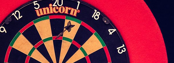 A dart sticks in the treble twenty on a dartboard