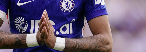 A Chelsea soccer player puts his hands together as if in prayer in a Premier League game