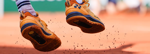 A tennis player's shoe on a clay court