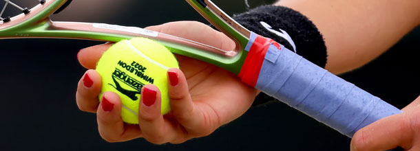 A tennis player holds the official Wimbledon Grand Slam ball