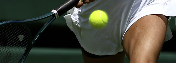 A tennis player hits a shot in the WTA event at Wimbledon