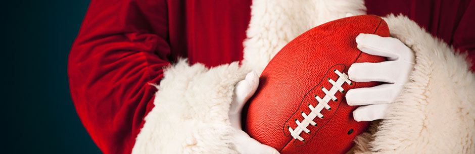 Santa is holding an American football in his hands